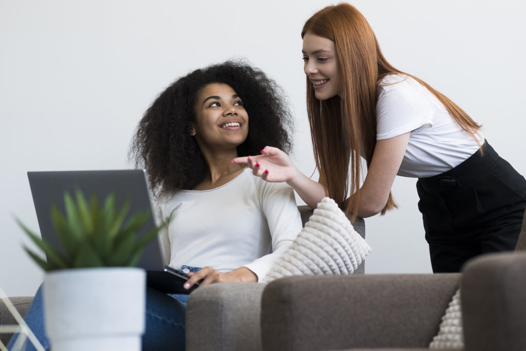 positive young women working together laptop